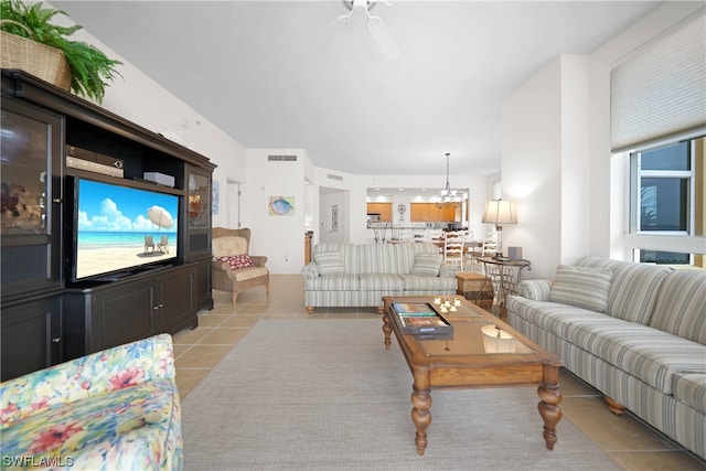 living room featuring light tile floors and ceiling fan with notable chandelier