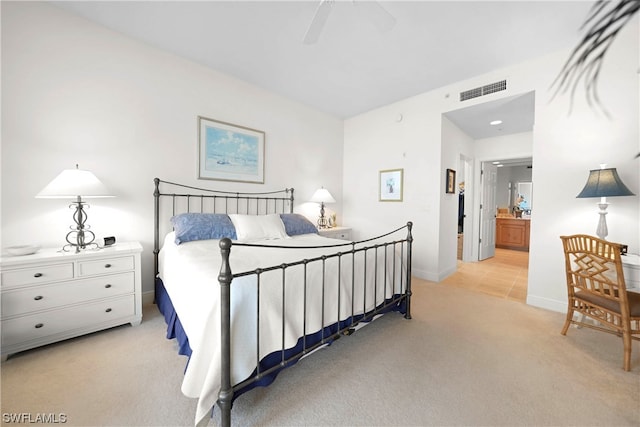 bedroom featuring light carpet, ceiling fan, and connected bathroom