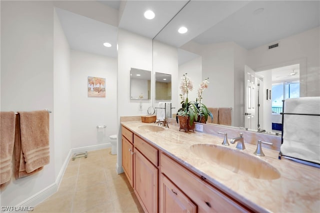 bathroom with double sink vanity, toilet, and tile flooring