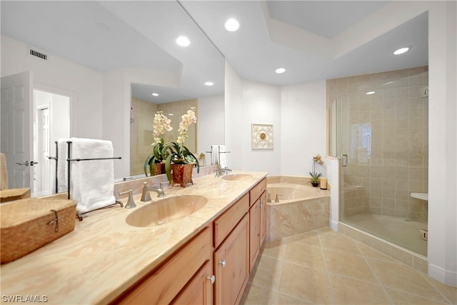 bathroom featuring tile floors, vanity with extensive cabinet space, separate shower and tub, and double sink