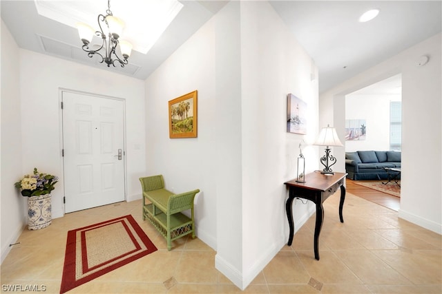 tiled foyer entrance featuring a notable chandelier and a tray ceiling