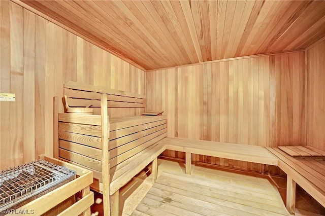 view of sauna / steam room with wooden walls, hardwood / wood-style floors, and wood ceiling