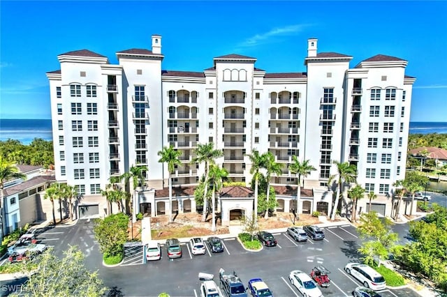 view of property featuring a water view and uncovered parking