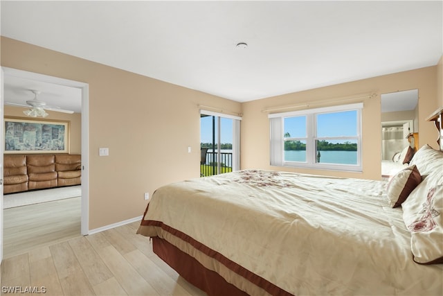 bedroom with a water view and light wood-type flooring