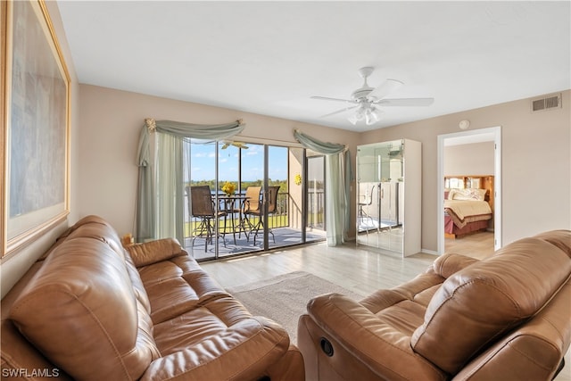 living room featuring ceiling fan and light hardwood / wood-style flooring