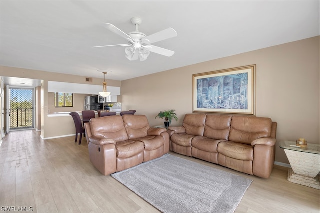 living room with light hardwood / wood-style floors and ceiling fan