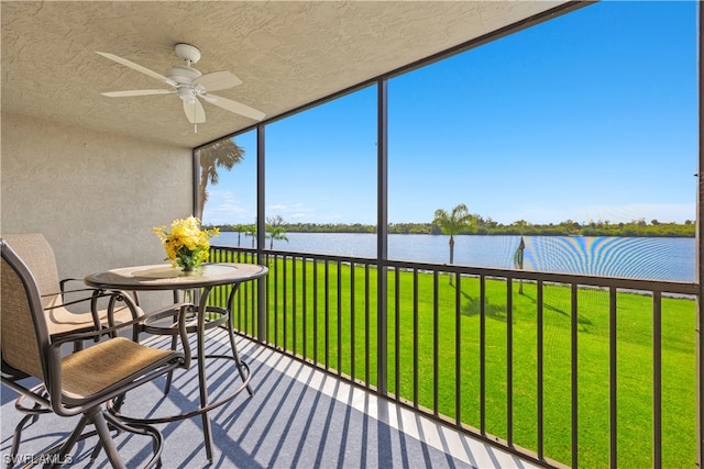 sunroom with a water view and ceiling fan