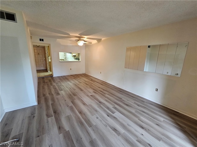 empty room featuring light hardwood / wood-style floors, a textured ceiling, and ceiling fan