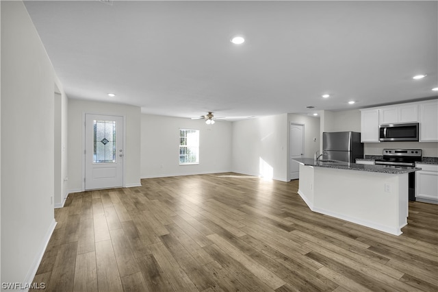 kitchen with wood-type flooring, ceiling fan, appliances with stainless steel finishes, and white cabinetry