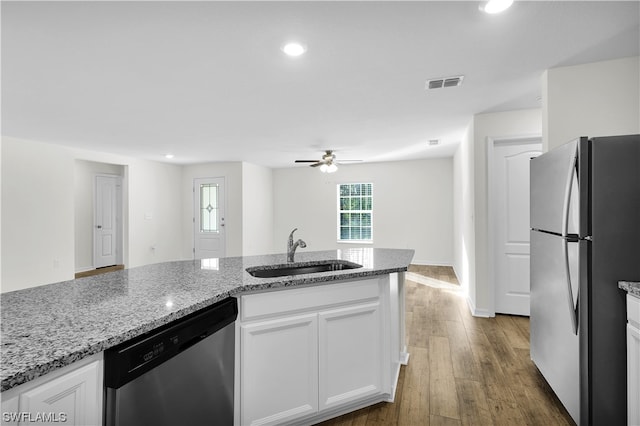 kitchen featuring light stone counters, appliances with stainless steel finishes, and white cabinetry