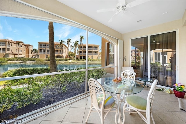 sunroom with a water view and ceiling fan