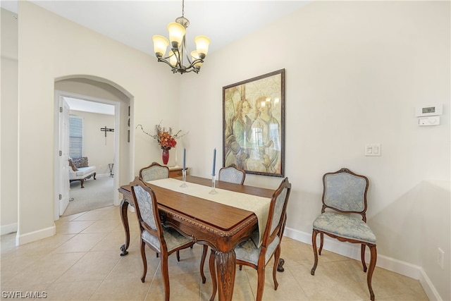 dining room with light tile floors and an inviting chandelier