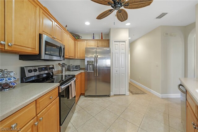 kitchen with light tile floors, stainless steel appliances, and ceiling fan