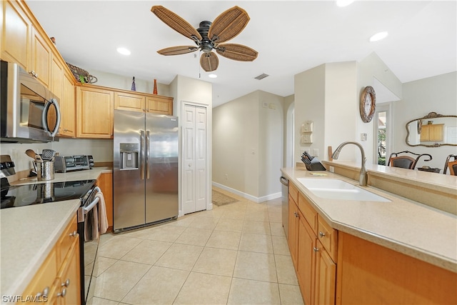 kitchen with light brown cabinetry, ceiling fan, light tile floors, sink, and appliances with stainless steel finishes