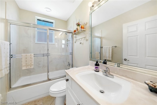 full bathroom featuring toilet, vanity with extensive cabinet space, shower / bath combination with glass door, and tile flooring