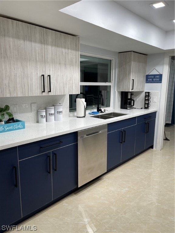 kitchen featuring stainless steel dishwasher, blue cabinetry, sink, and tasteful backsplash