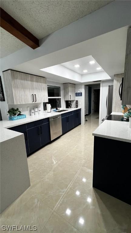 kitchen with beamed ceiling, stainless steel appliances, kitchen peninsula, and sink