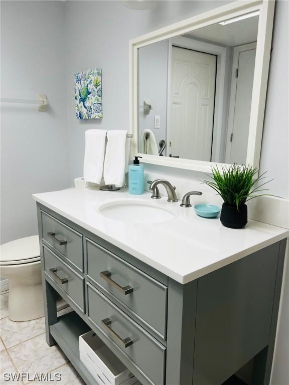 bathroom with tile patterned flooring, vanity, and toilet