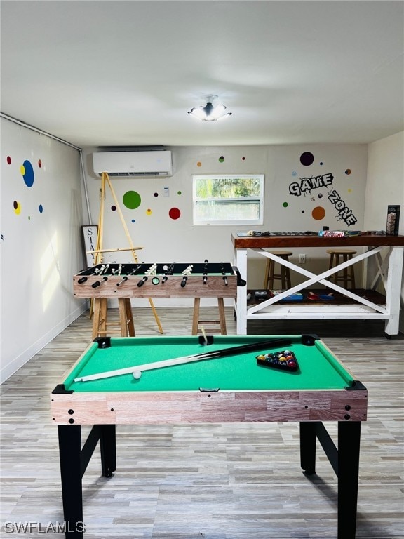 rec room featuring an AC wall unit, hardwood / wood-style floors, and pool table