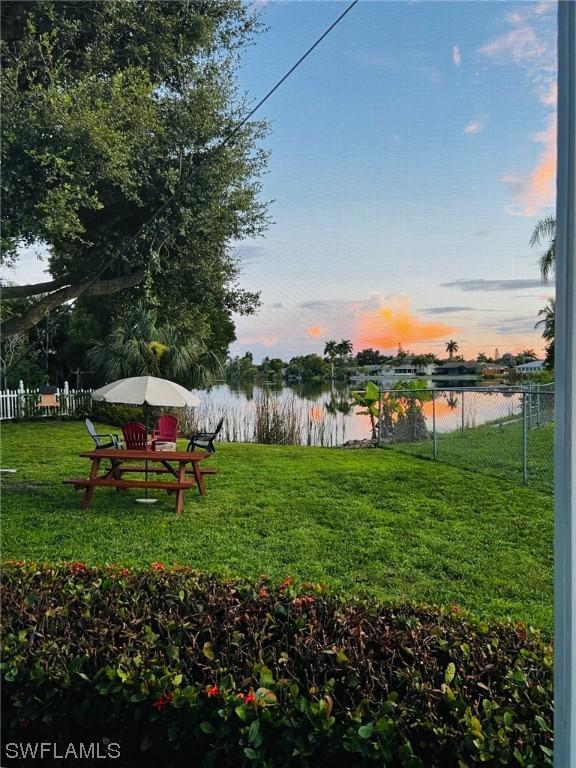 yard at dusk featuring a water view