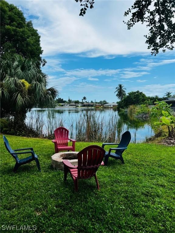 view of yard with a water view and an outdoor fire pit