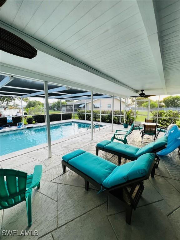 view of swimming pool featuring a lanai and a patio area