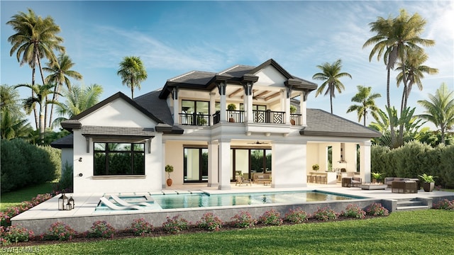 rear view of house featuring a balcony, an outdoor hangout area, ceiling fan, a lawn, and a patio