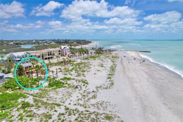 drone / aerial view featuring a water view and a beach view