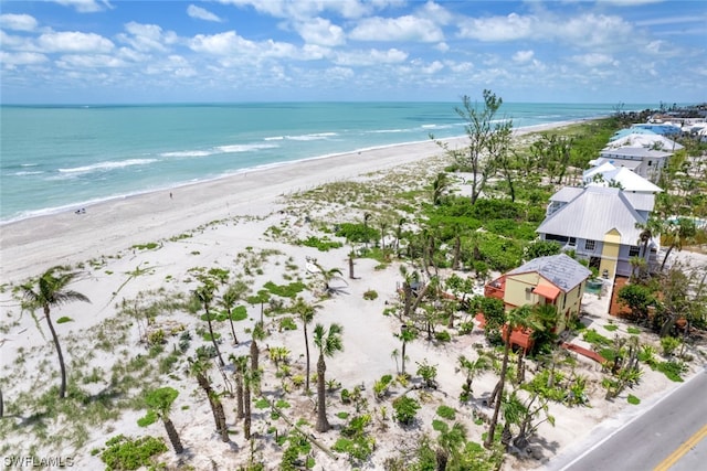 birds eye view of property with a water view and a beach view