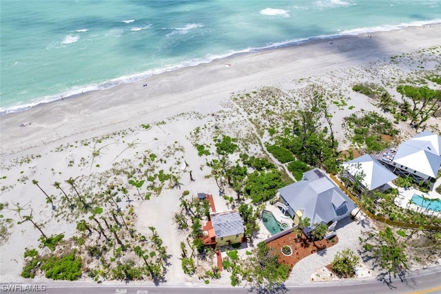 drone / aerial view featuring a water view and a beach view