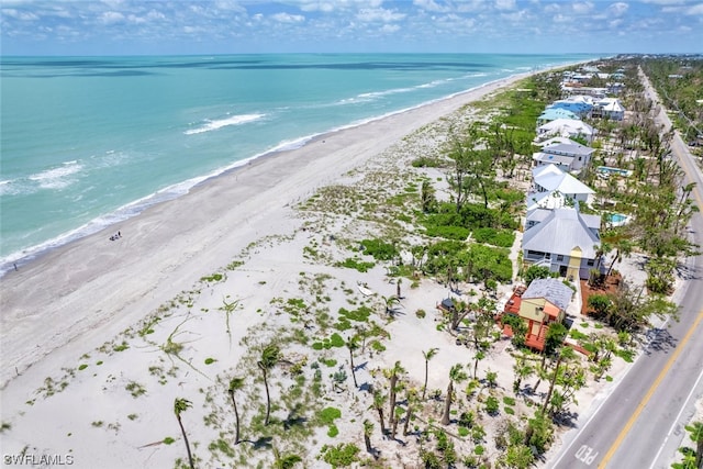 birds eye view of property with a water view and a view of the beach