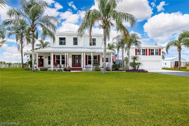 view of front facade with a porch, a front yard, and a garage