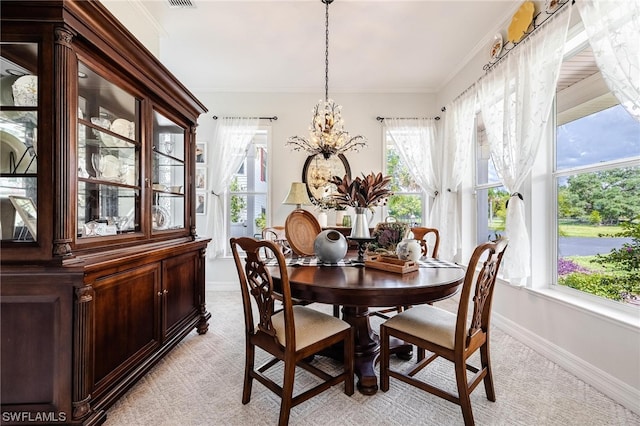 dining room featuring plenty of natural light, crown molding, and light colored carpet