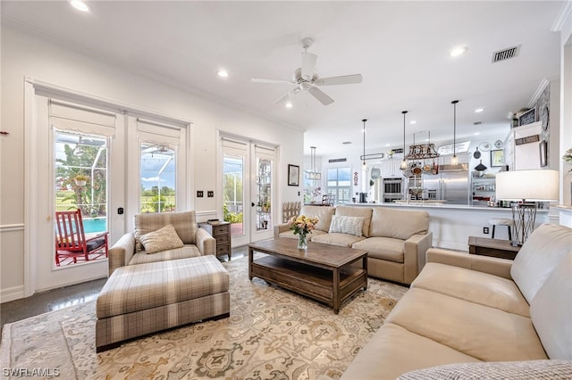 carpeted living room with crown molding, french doors, and ceiling fan