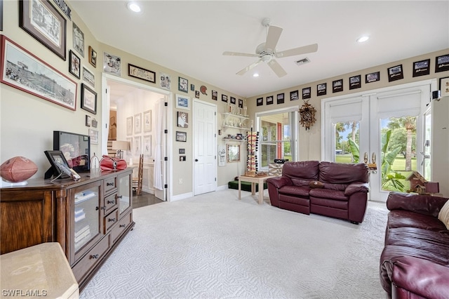 living room featuring light carpet, ceiling fan, and french doors