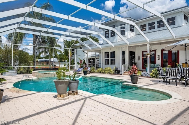 view of swimming pool featuring a patio area, an in ground hot tub, and glass enclosure