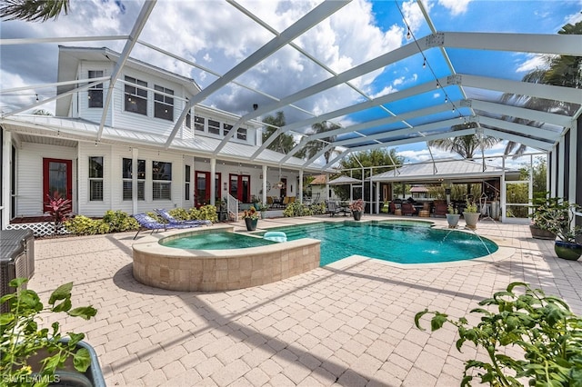 view of swimming pool with an in ground hot tub, a lanai, pool water feature, and a patio