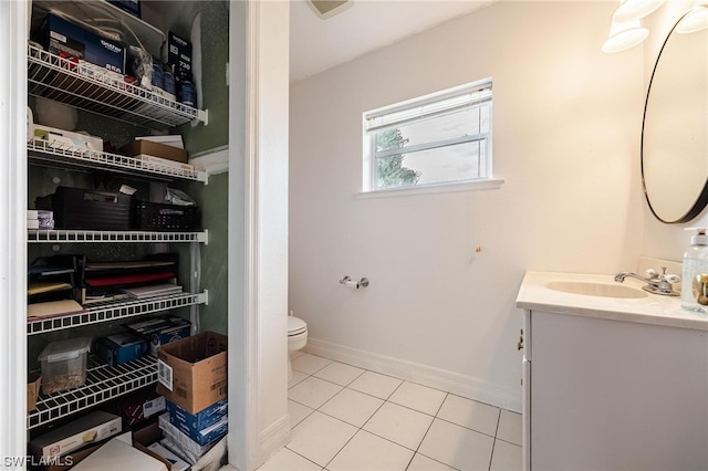 bathroom featuring toilet, vanity, and tile flooring