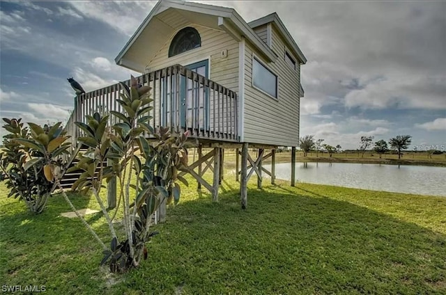 view of side of property with a yard and a water view