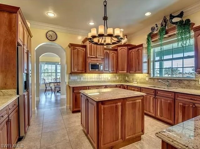 kitchen featuring tasteful backsplash, a kitchen island, sink, and a wealth of natural light