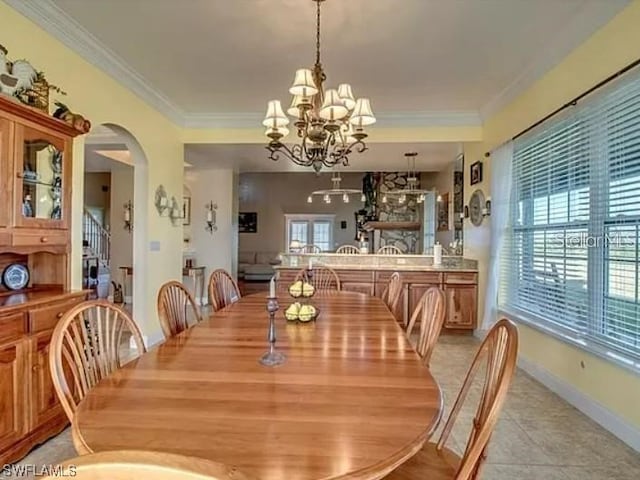 tiled dining space with a chandelier and ornamental molding