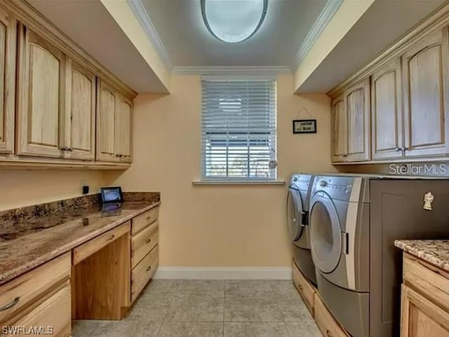 washroom featuring crown molding, light tile floors, cabinets, and washing machine and dryer