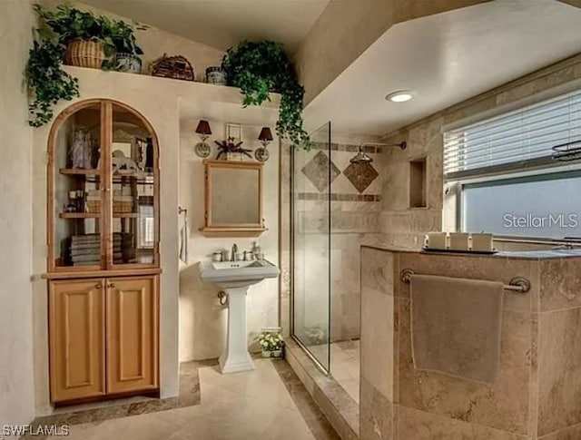 bathroom featuring an enclosed shower and tile flooring