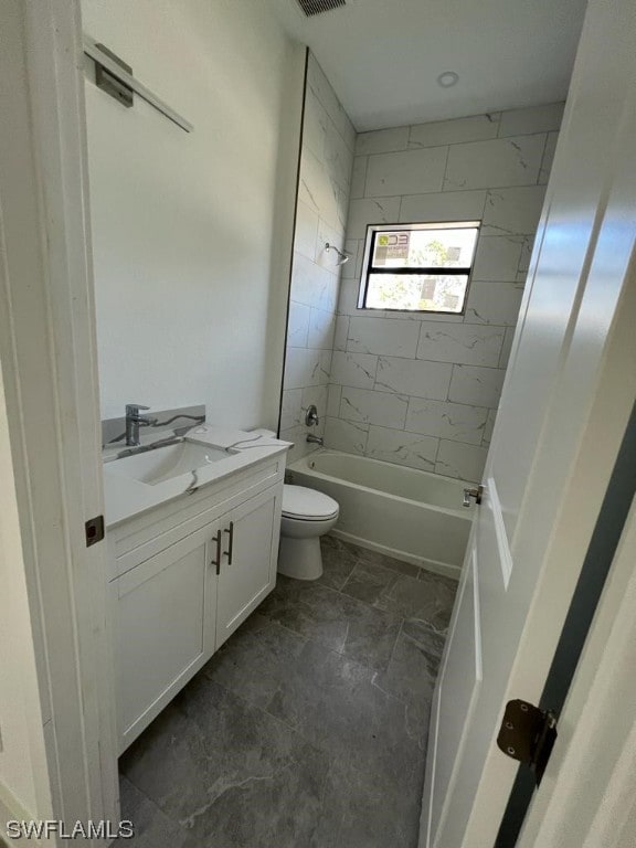 full bathroom with vanity, tiled shower / bath combo, tile floors, and toilet