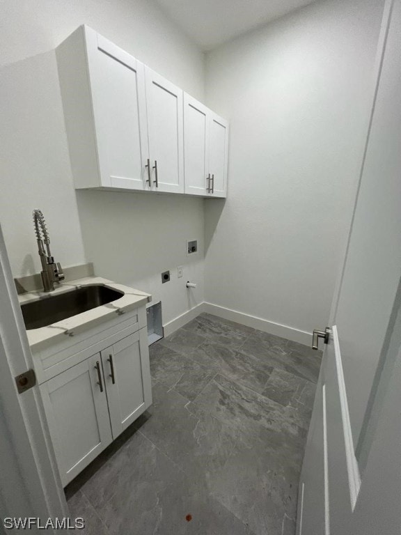 clothes washing area with hookup for an electric dryer, cabinets, hookup for a washing machine, dark tile flooring, and sink