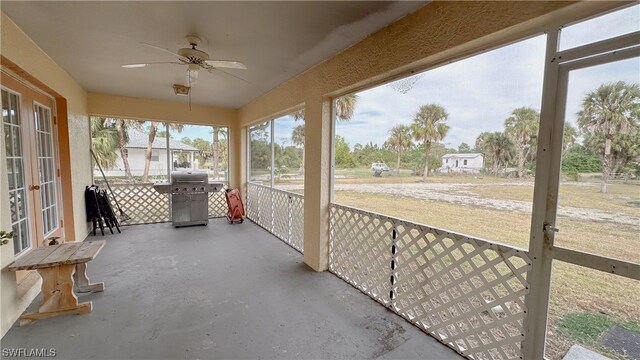 unfurnished sunroom featuring ceiling fan