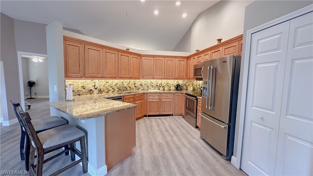 kitchen featuring high vaulted ceiling, kitchen peninsula, appliances with stainless steel finishes, and tasteful backsplash