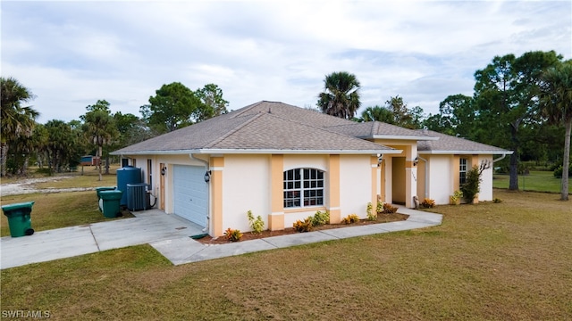 view of front of home featuring cooling unit, a front yard, and a garage