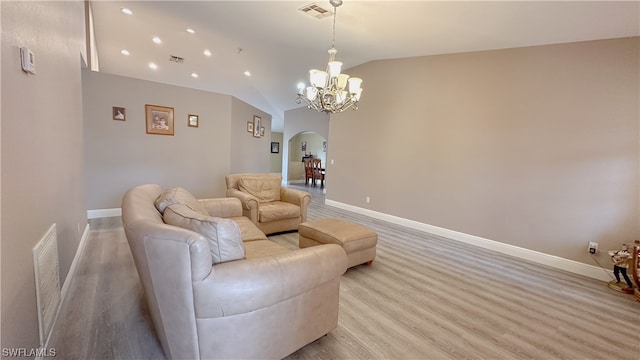 living room with light hardwood / wood-style flooring, vaulted ceiling, and a notable chandelier