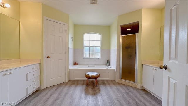 bathroom with shower with separate bathtub, wood-type flooring, and vanity